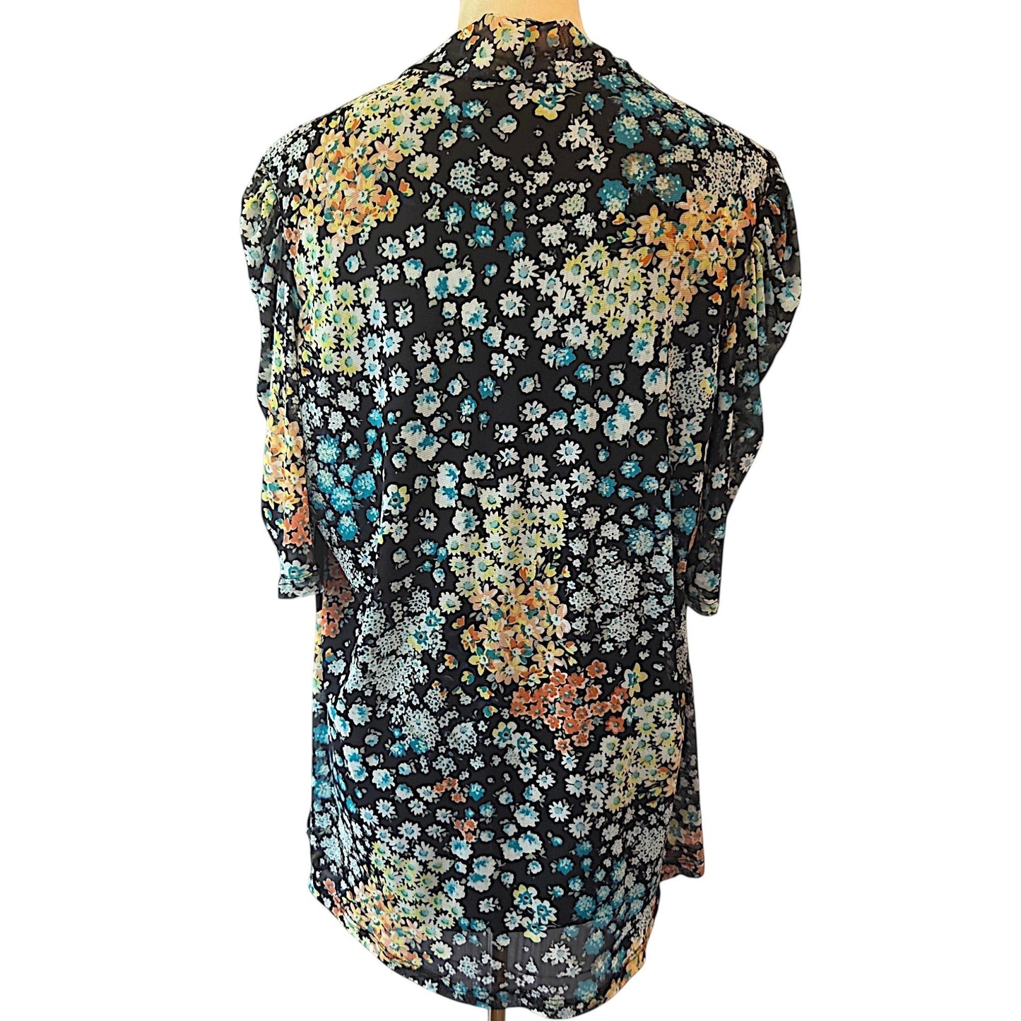 Back view of Birds of a Feather Boutique & Soy Wax Candle Company floral blouse with blue, orange, and yellow ditzy print