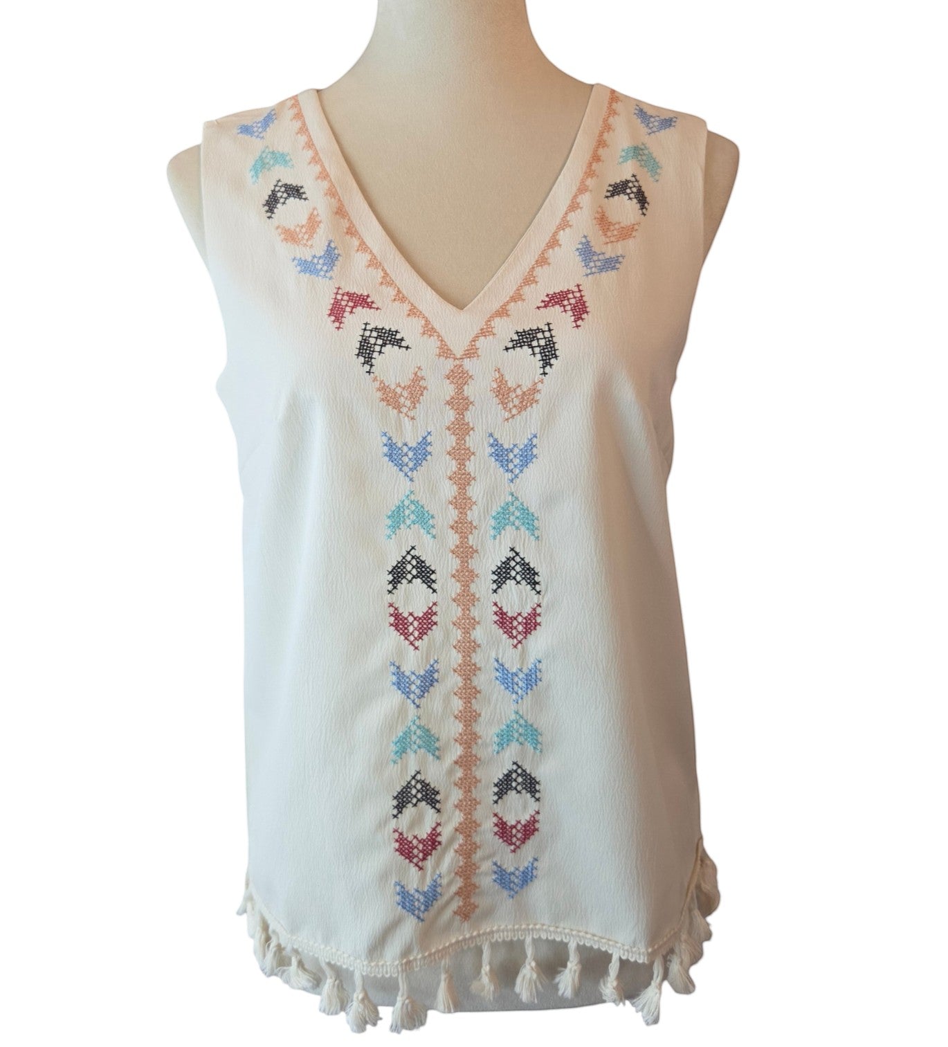 Birds of a Feather Boutique & Soy Wax Candle Company cream sleeveless V-neck blouse with colorful embroidery and tassels