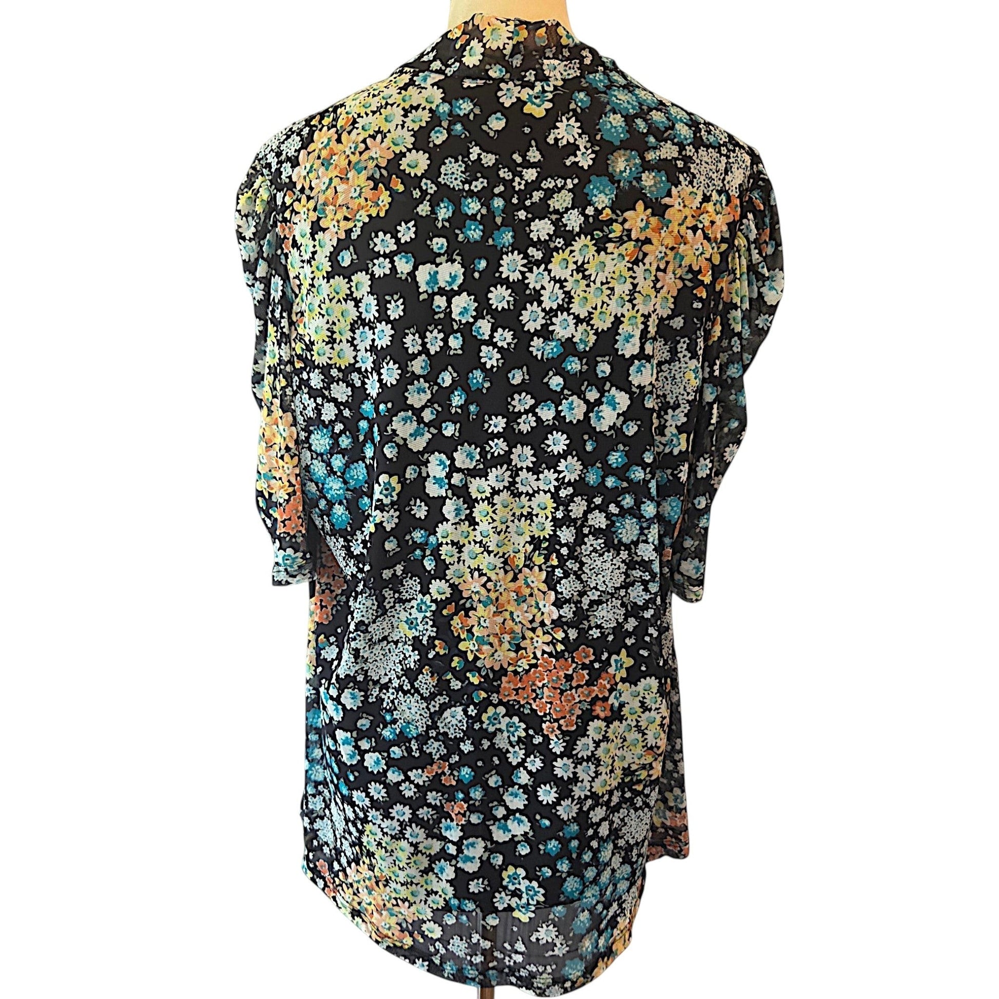 Back view of Birds of a Feather Boutique & Soy Wax Candle Company floral blouse with blue, orange, and yellow ditzy print